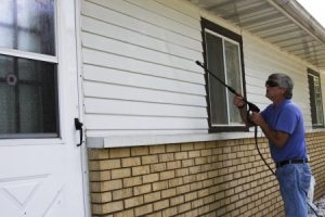 14899814 - home owner pressure washing the siding of his house