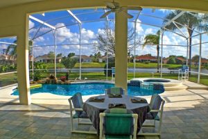 65966501 - a view from a lanai of a pool, spa and lake.